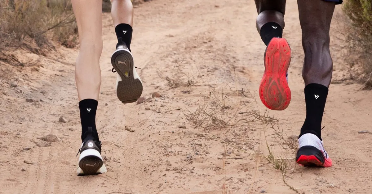 Deux coureurs sur chemin de terre avec les chaussettes Versus Socks Active noires