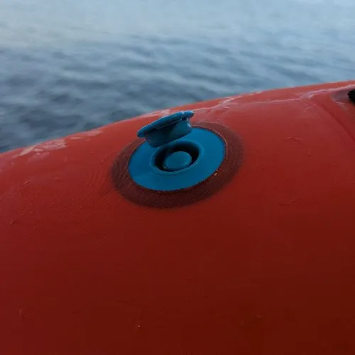 Valve de gonflage bleue de la bouée OWS 100 en gros plan, au bord de l'eau